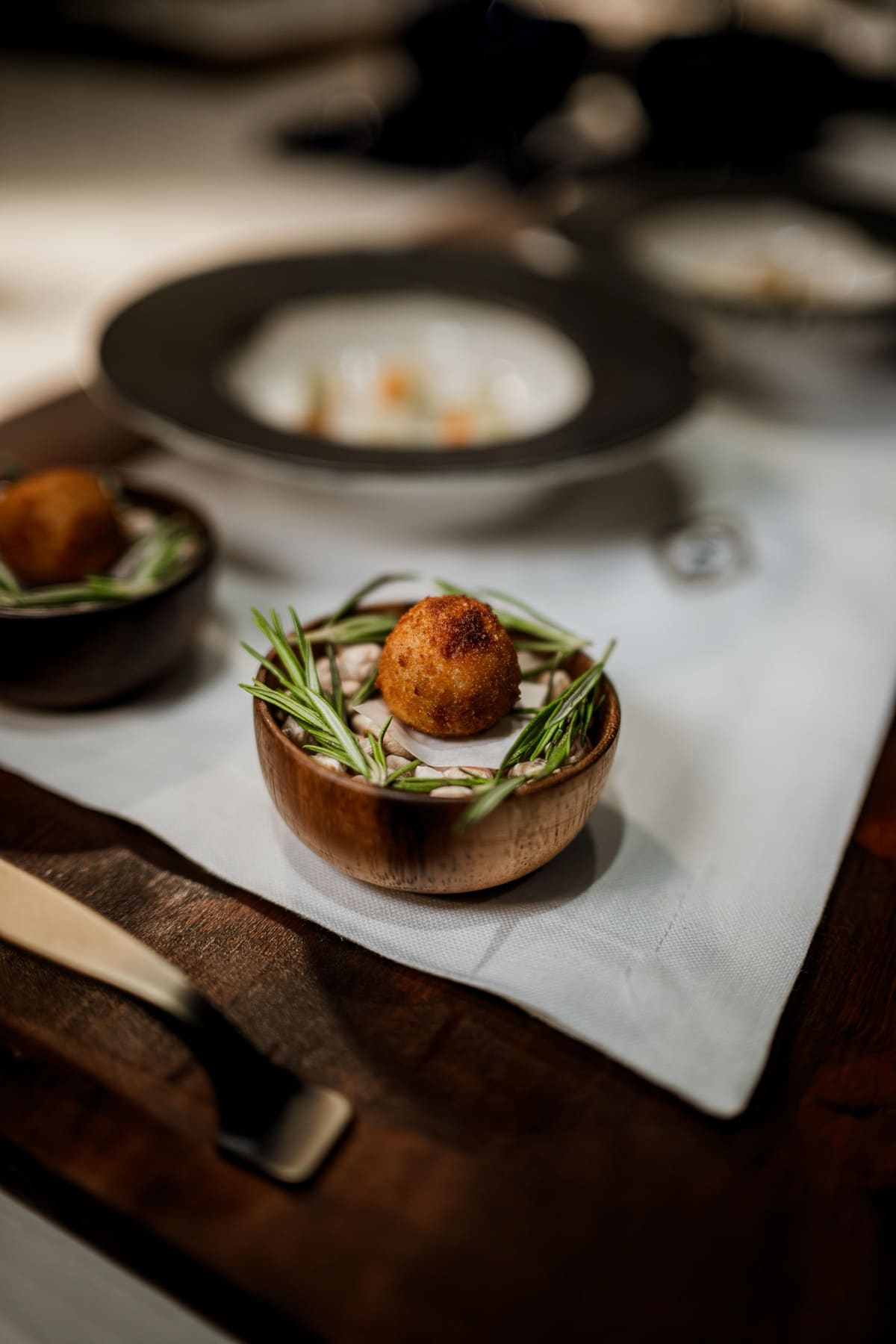 Croqueta de puchero sobre lecho de alubias en el menú degustación de INIZIO